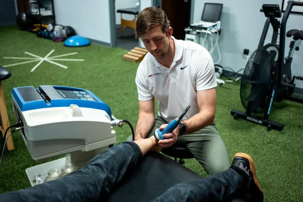 Dr. Drew using Focused-Shockwave-Therapy-(ESWT) on a patient